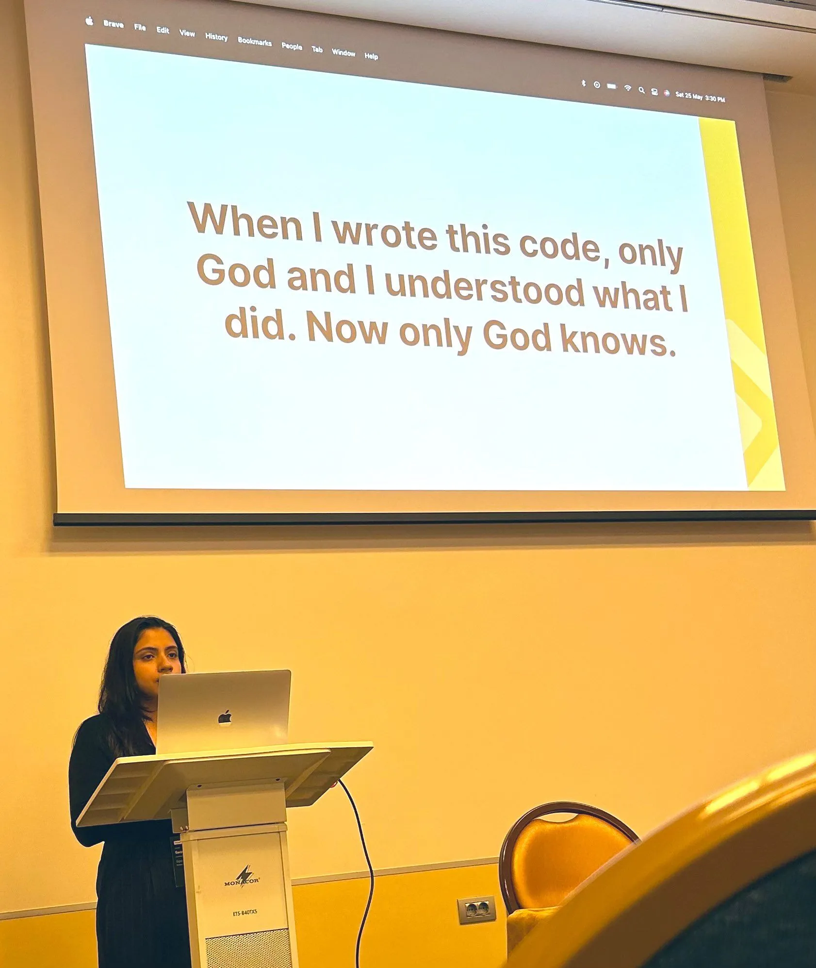 Swastika at the podium at PyCon Italy, with a joke slide about old code on screen