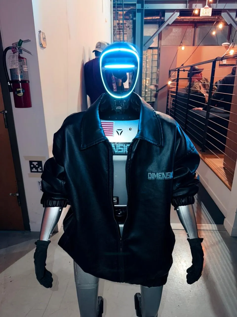 A humanoid robot wearing a black Dimensional jacket at the event